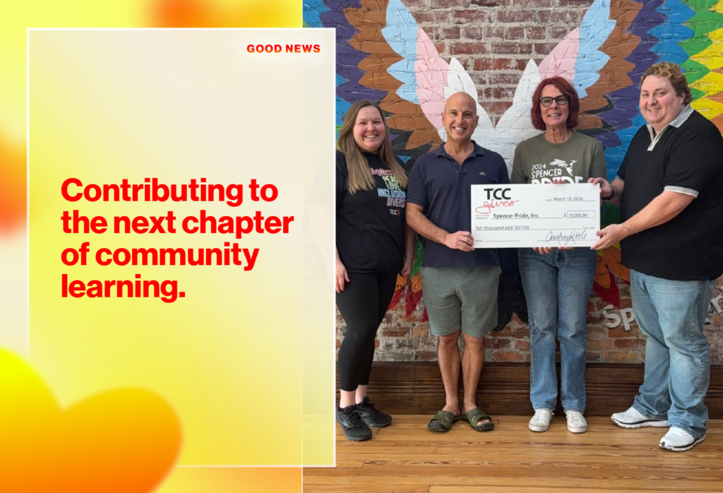 Left panel shows bold red text 'Contributing to the next chapter of community learning' with a soft yellow gradient; right side shows four people presenting a large check to Spencer Pride, Inc. for $10,000 in front of a colorful mural inside a wood-floored room.