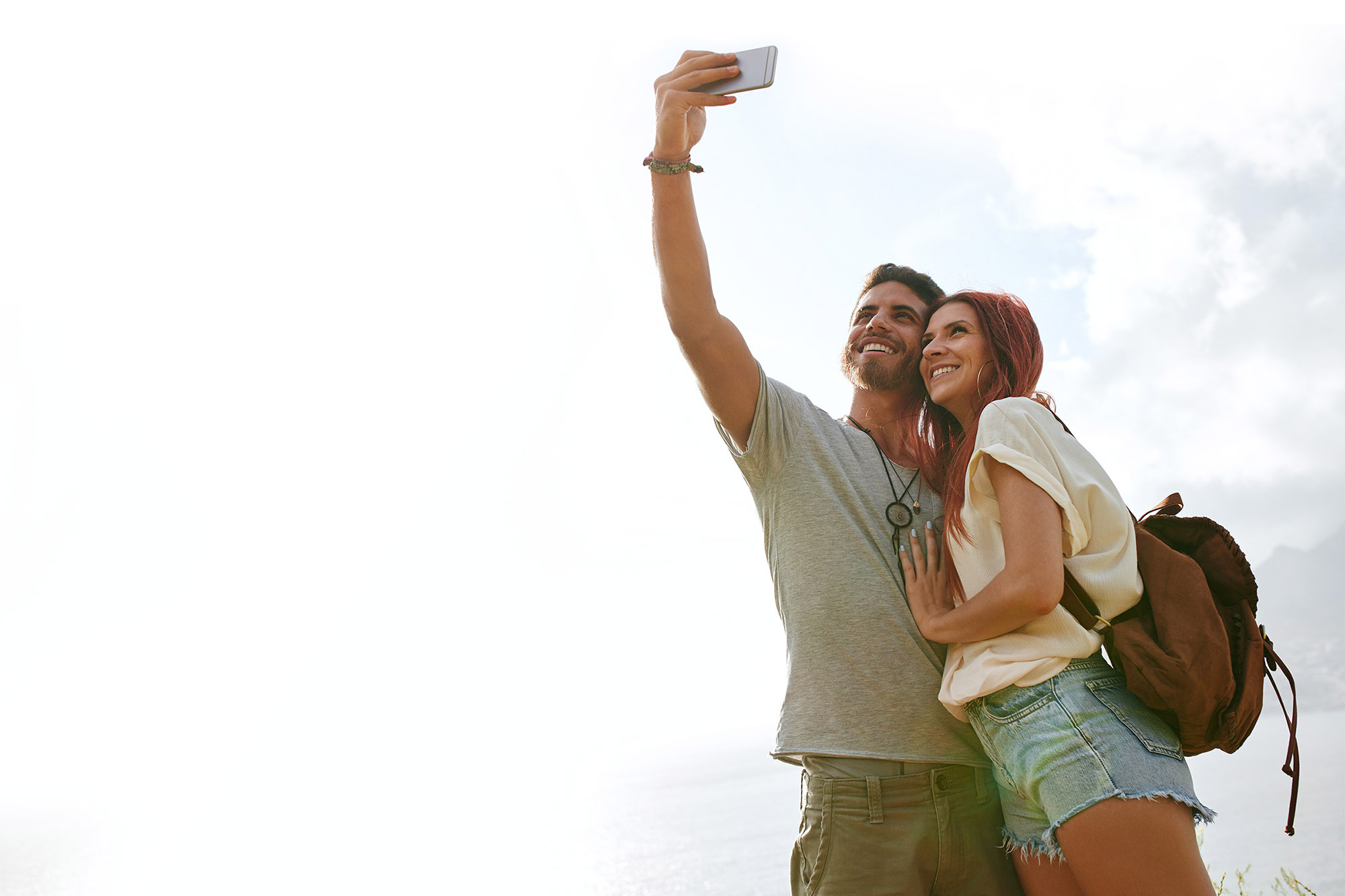 Man and woman holding up phone to take a selfie